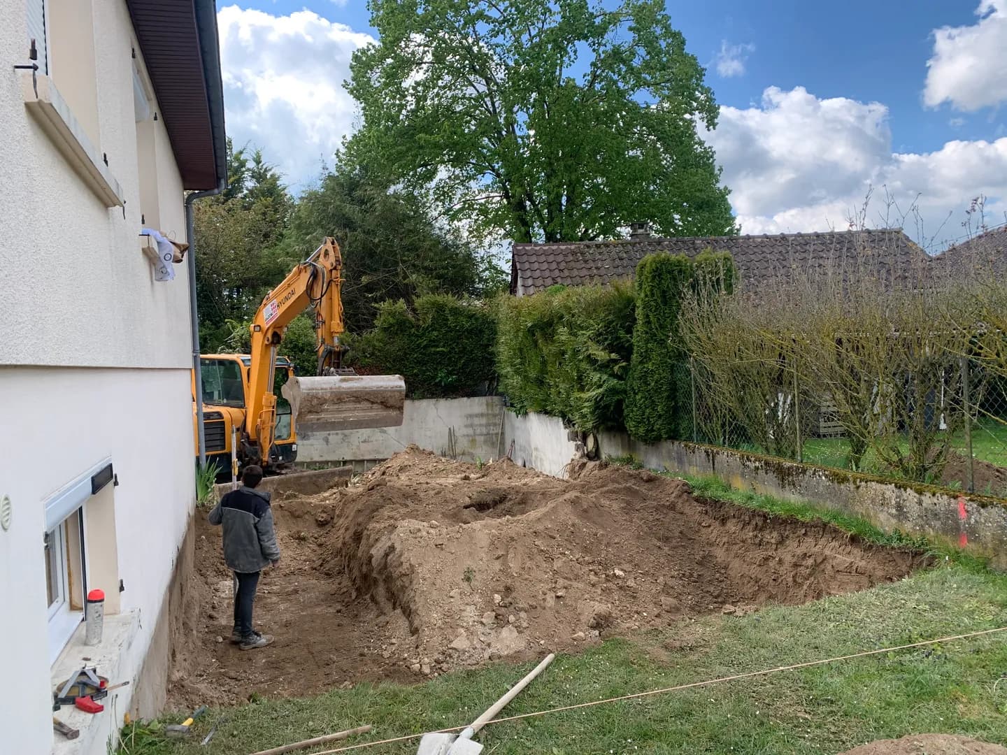 Terrassement au pied de la maison pour préparer l’emprise de l’agrandissement.