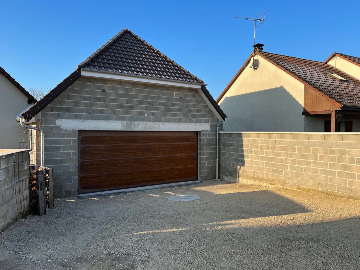 Porte de garage en place, avant l’enduit de la façade.