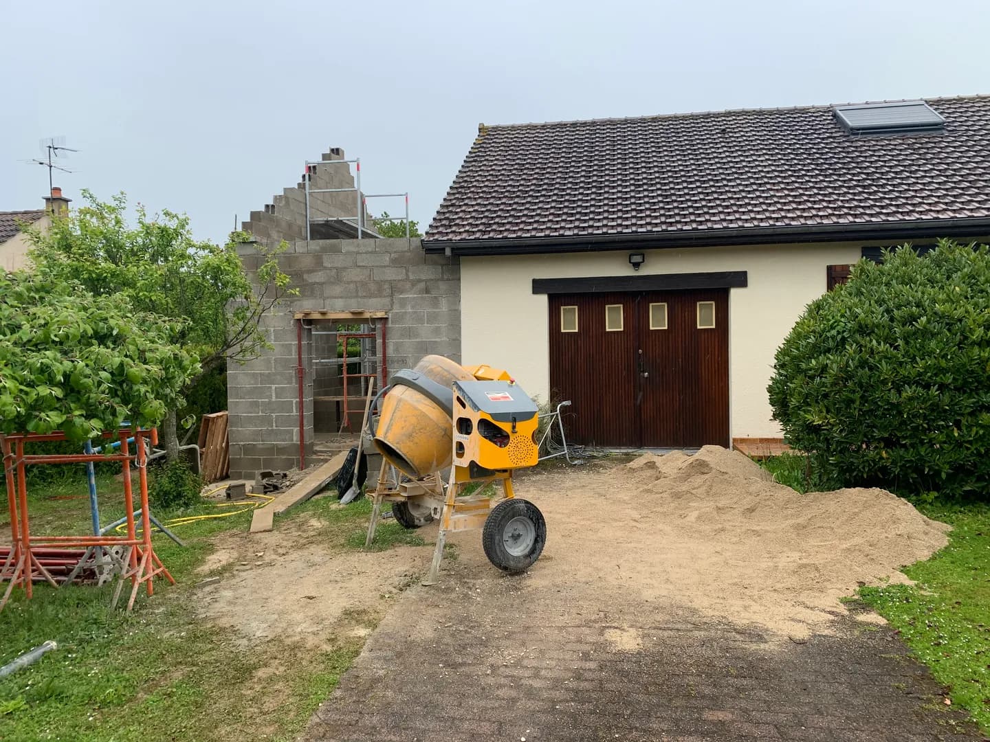Murs de l’extension en cours d’élévation au côté du pignon existant.