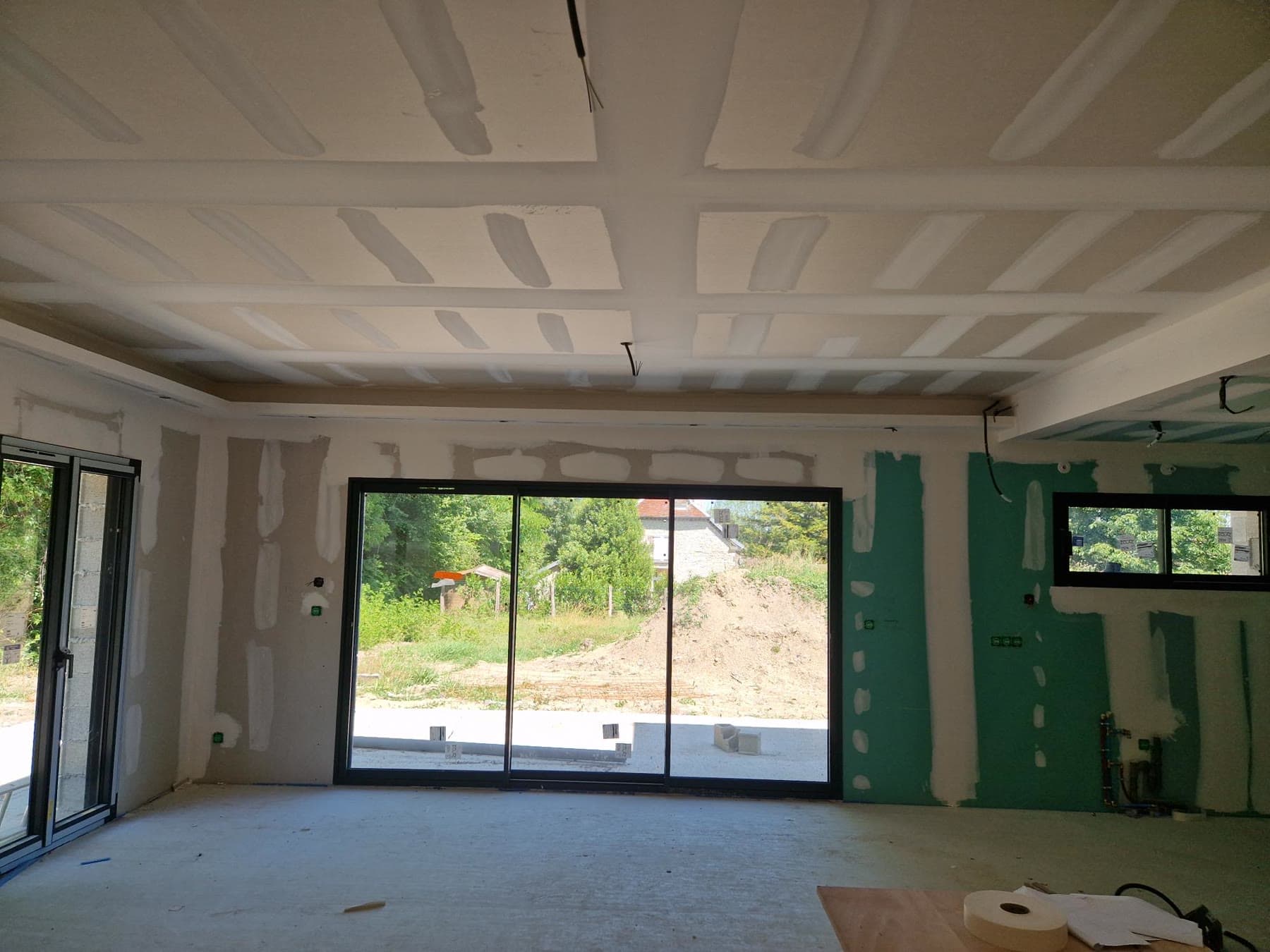 Plafond et menuiserie dans une pièce en cours d’aménagement.