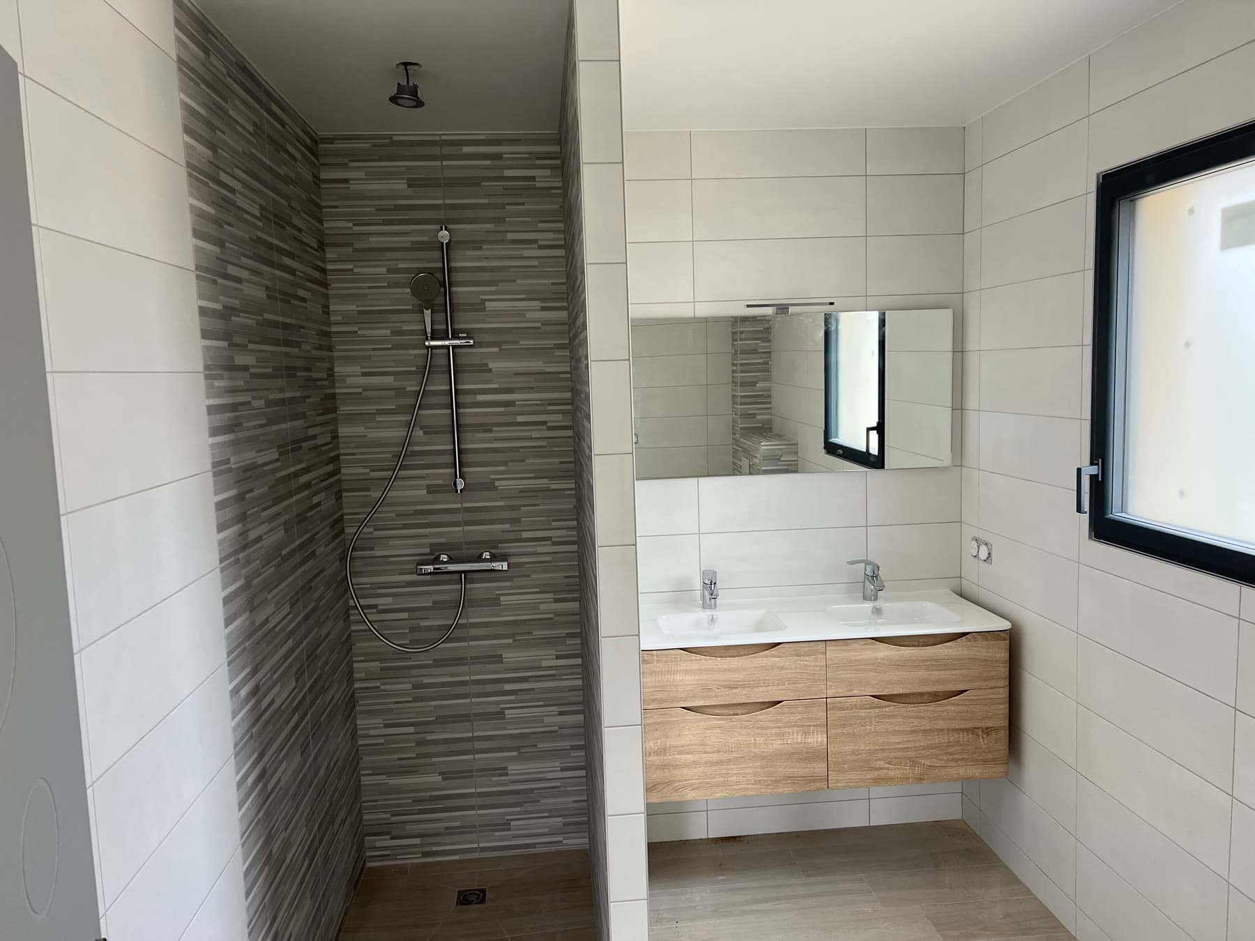 Salle de bains avec douche et meuble vasque.