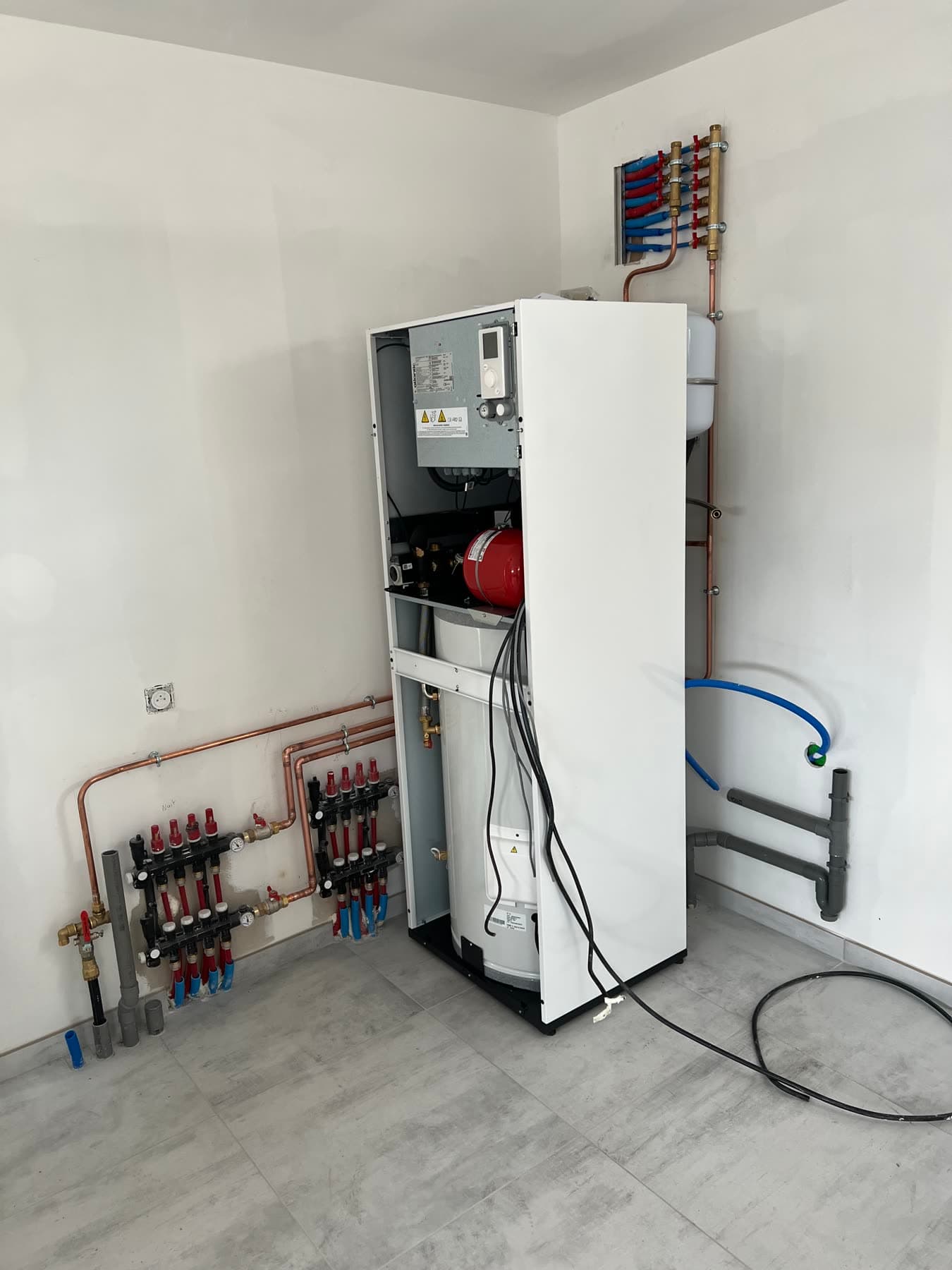 Équipement technique et collecteurs installés dans le local dédié.