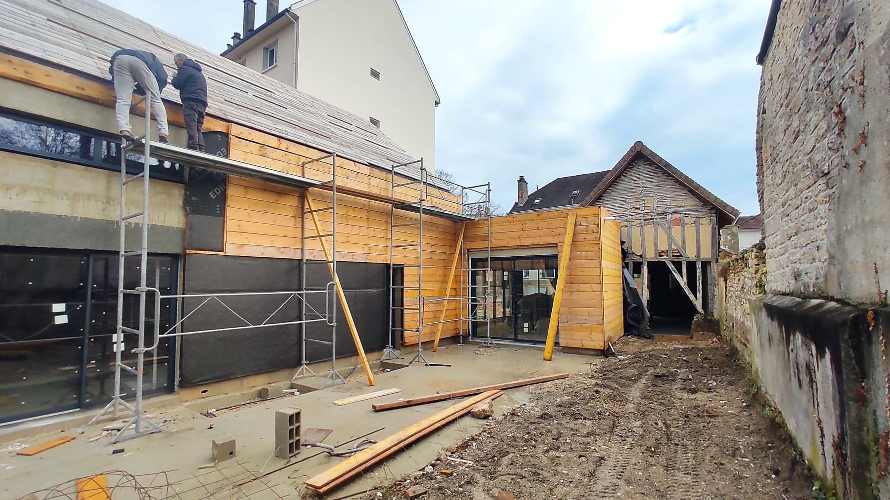 Travail de couverture et poursuite du bardage en façade.