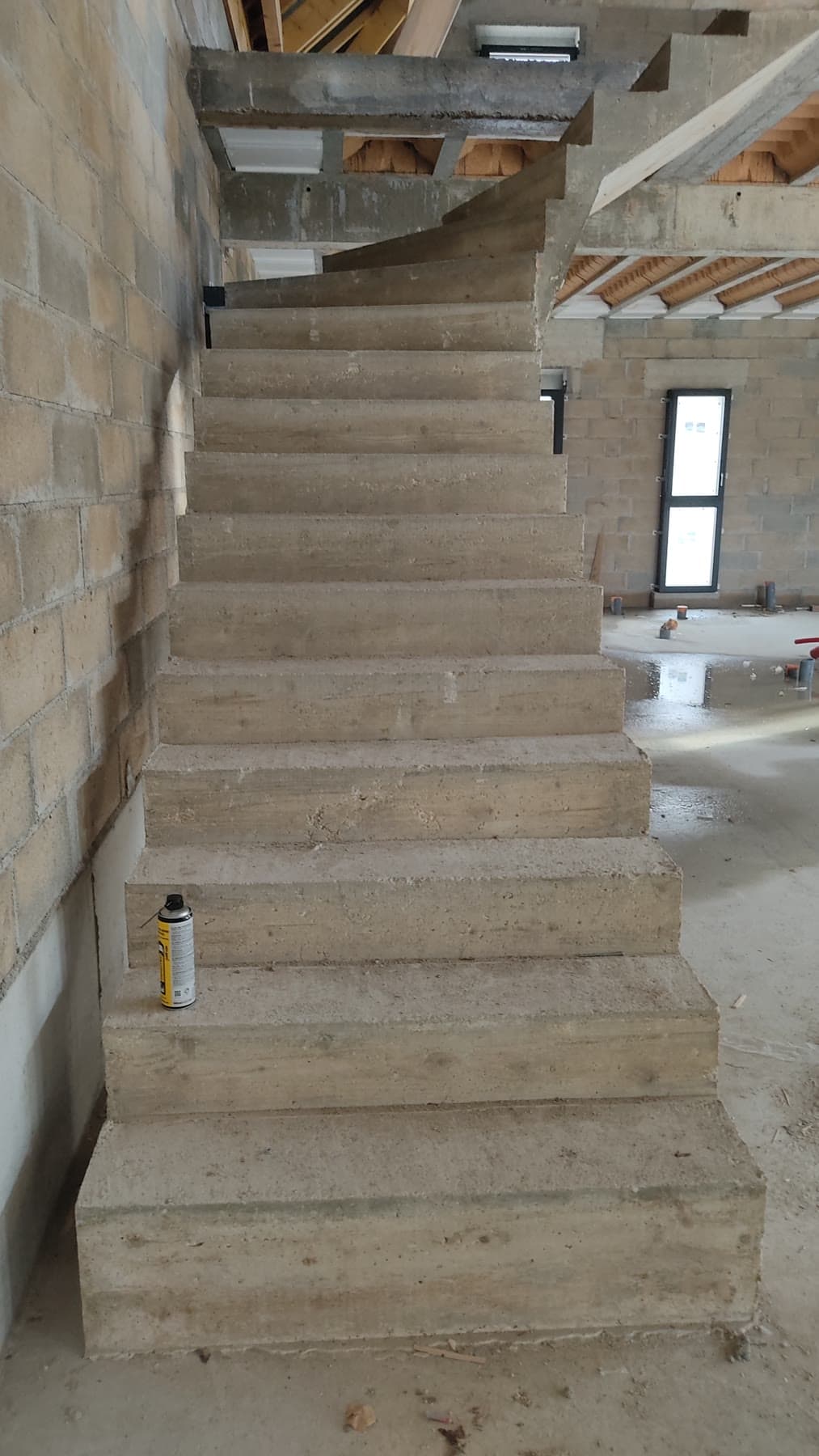 Escalier en béton reliant les différents niveaux de la maison.