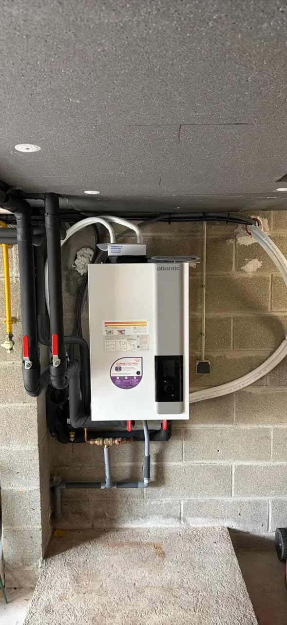 Module intérieur de la pompe à chaleur fixé au mur du local technique.