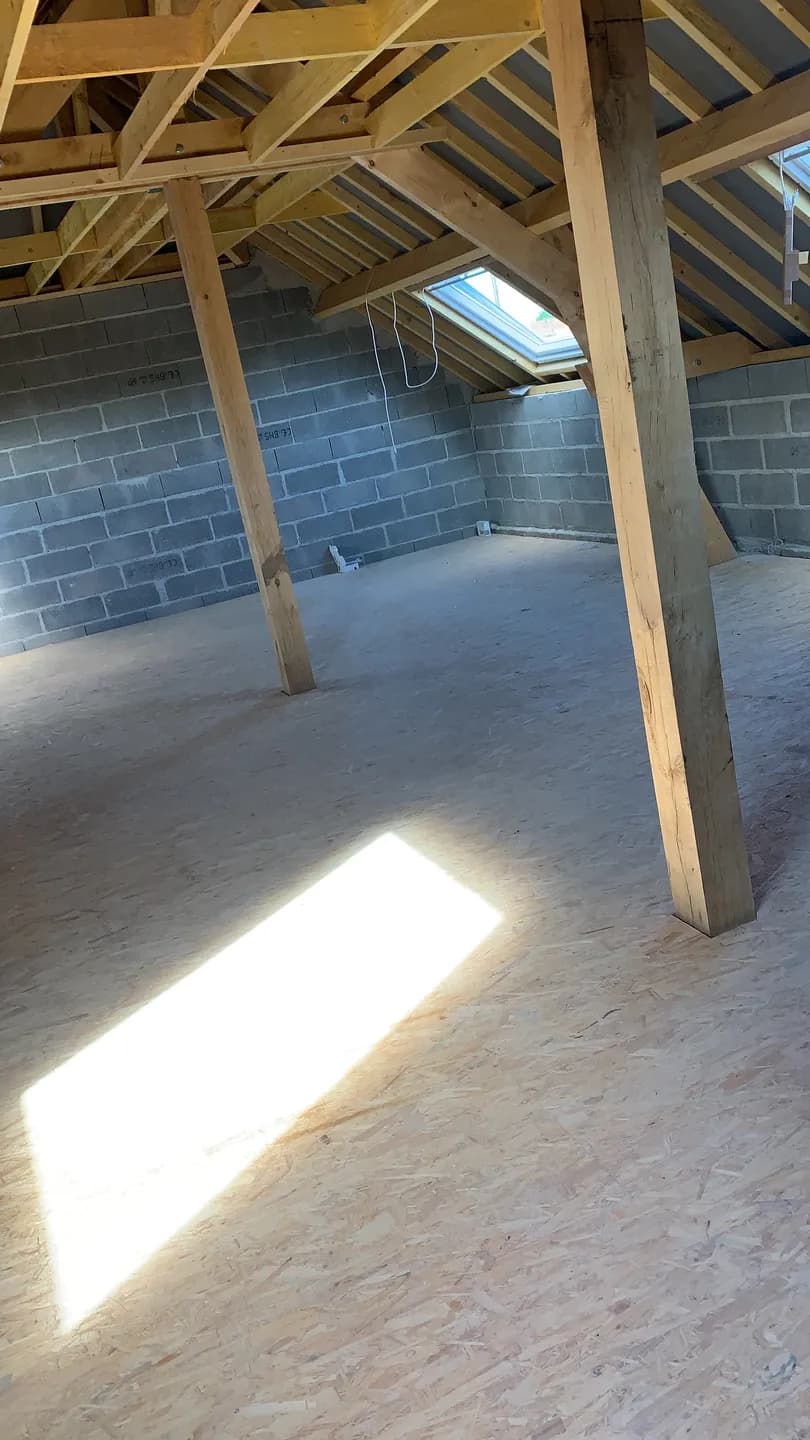 Charpente intérieure et volume sous toiture pendant la reconstruction.