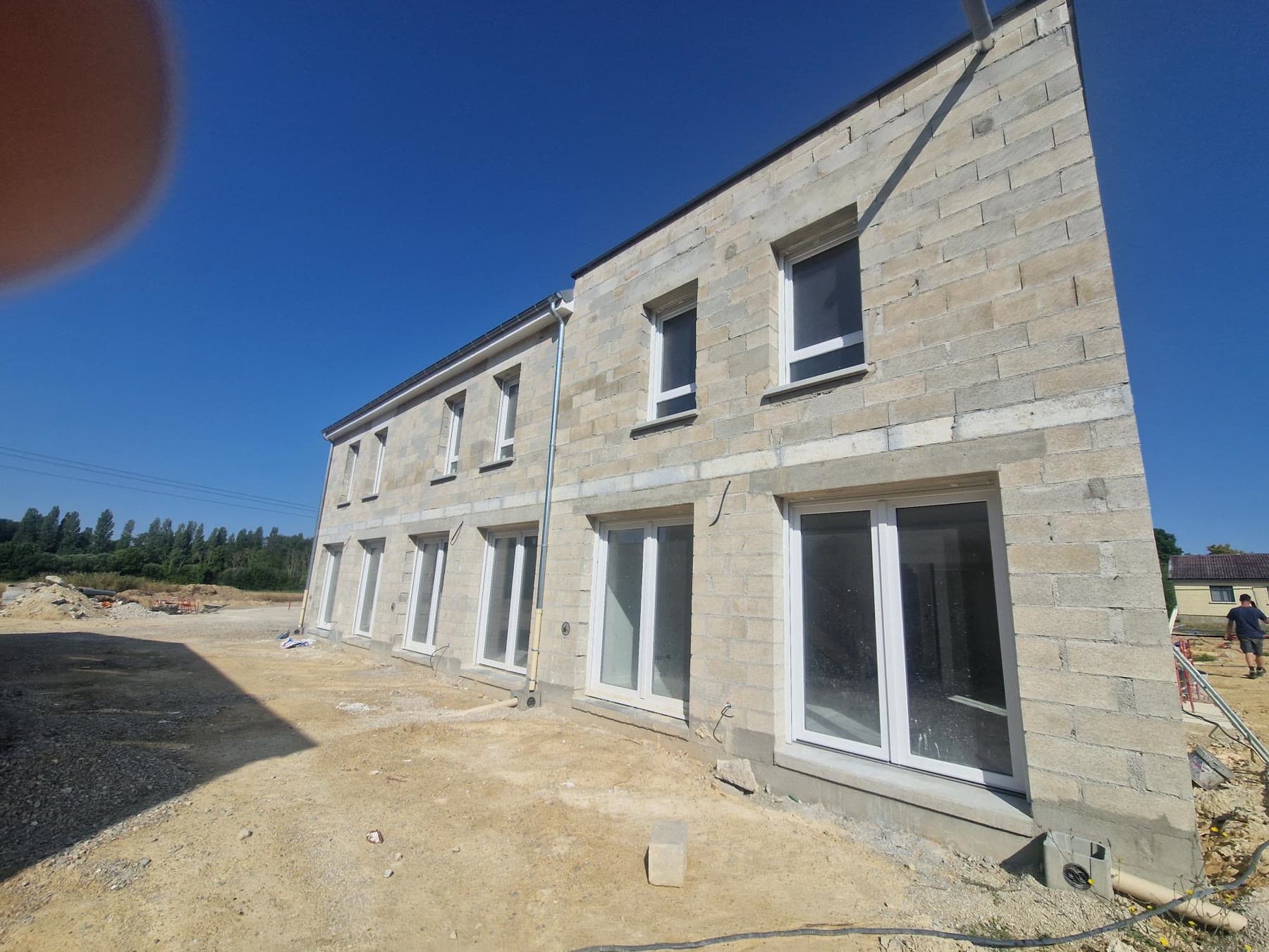 Façades avec menuiseries avant enduit.