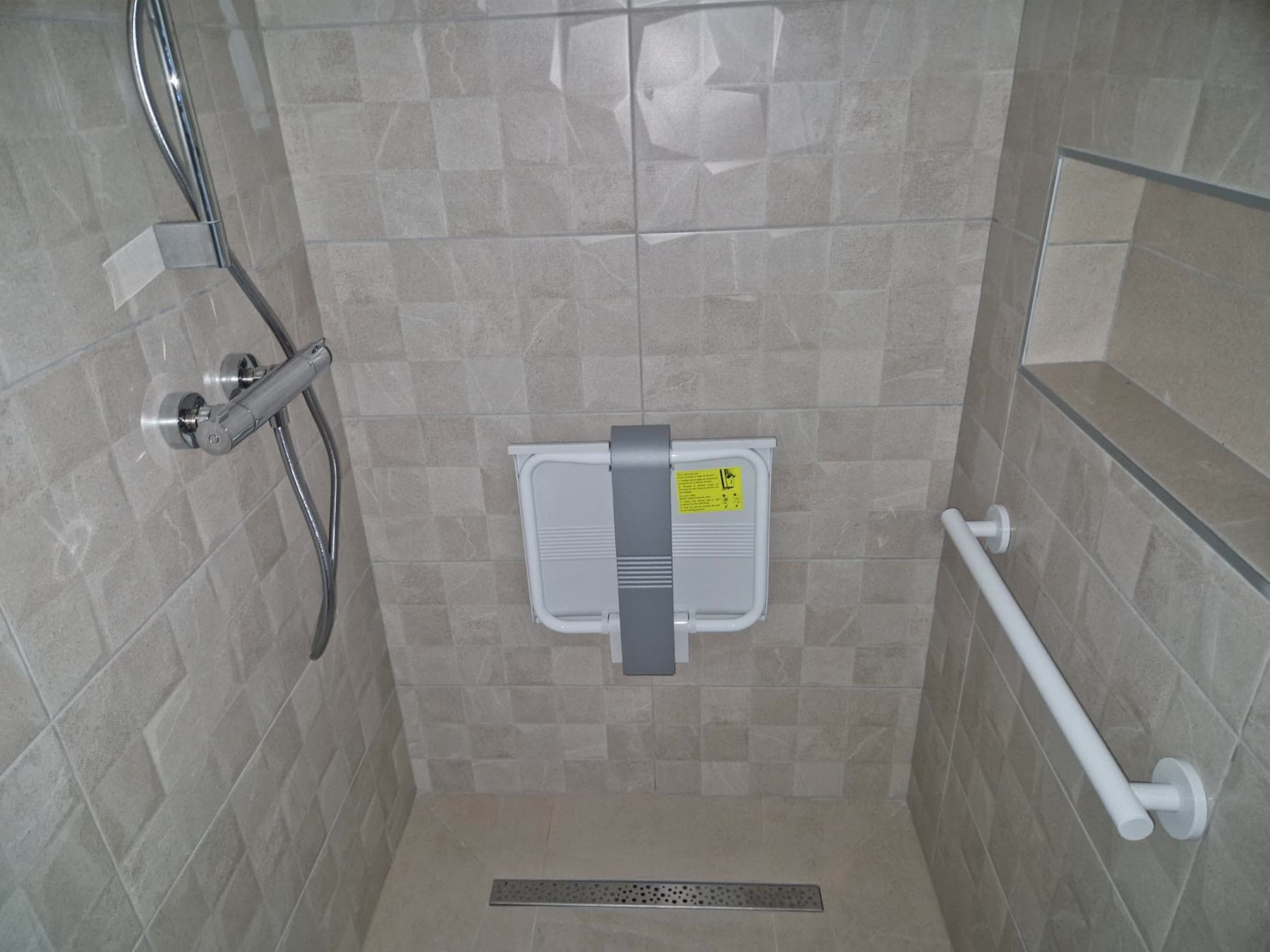 Douche carrelée et robinetterie.