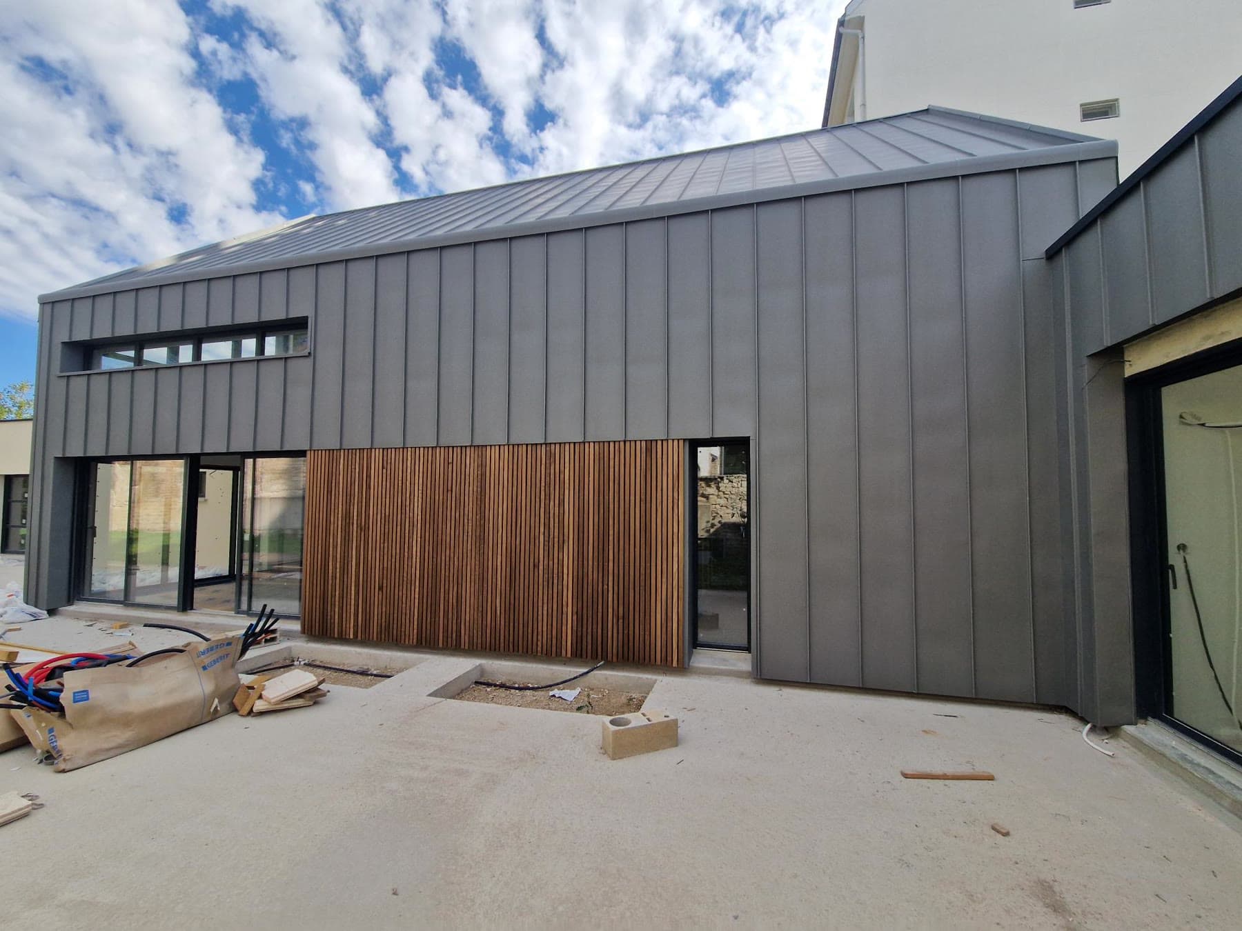 Bardage zinc et parement bois vertical.