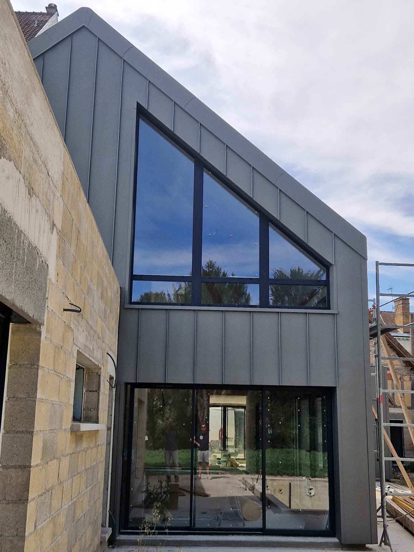Partie haute bardée et façade vitrée.