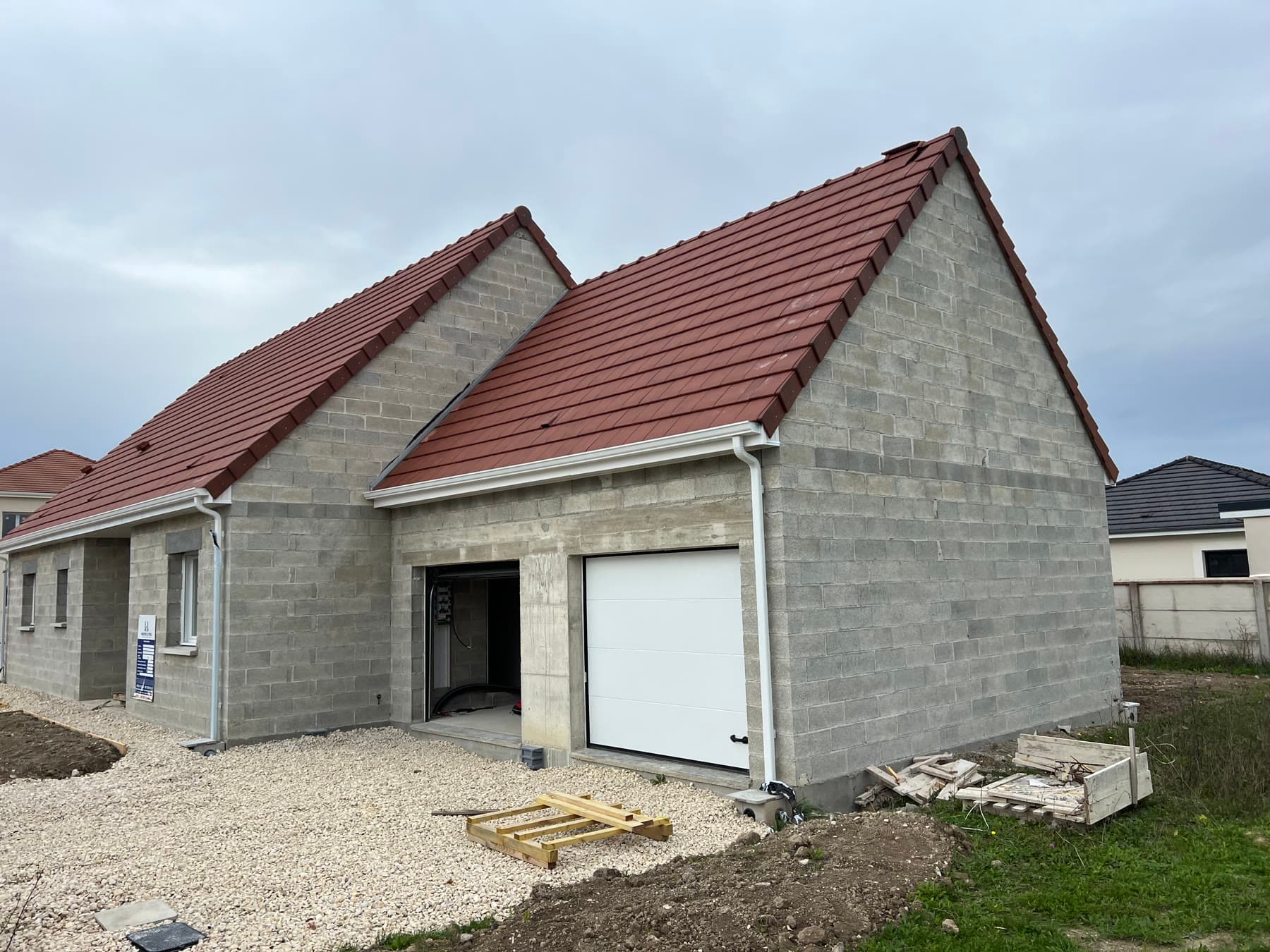 Maison couverte avec garage et menuiseries.