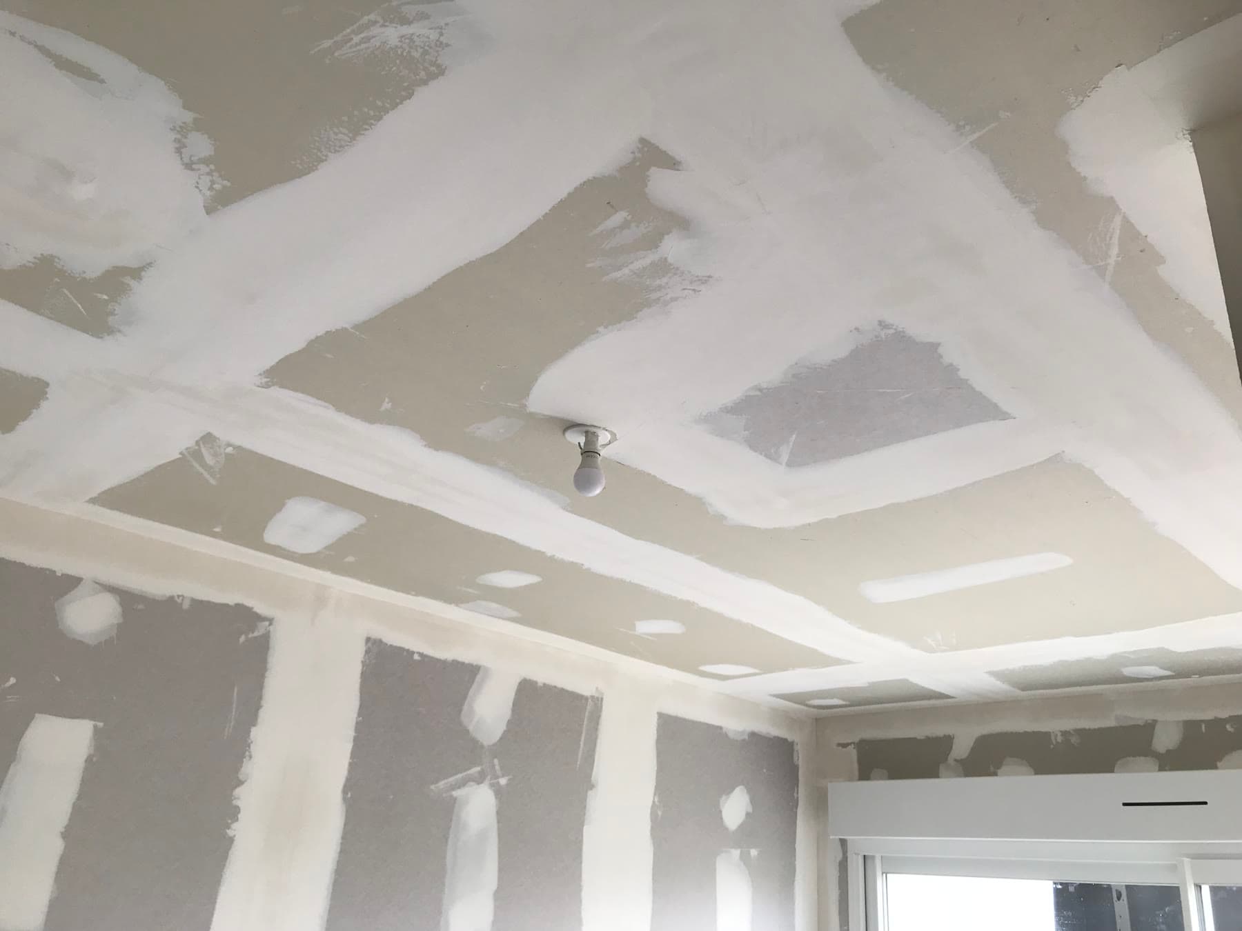 Traitement des joints et reprises du plafond avant les finitions.